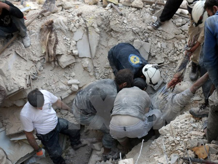 Tình nguyện viên Syria chuyển thi thể một nạn nhân sau một vụ không kích tại Aleppo ngày 4/10.